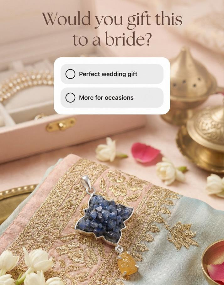 Jewelry with a blue sapphire gem stone and gold accents on a decorative surface with flowers and a box.