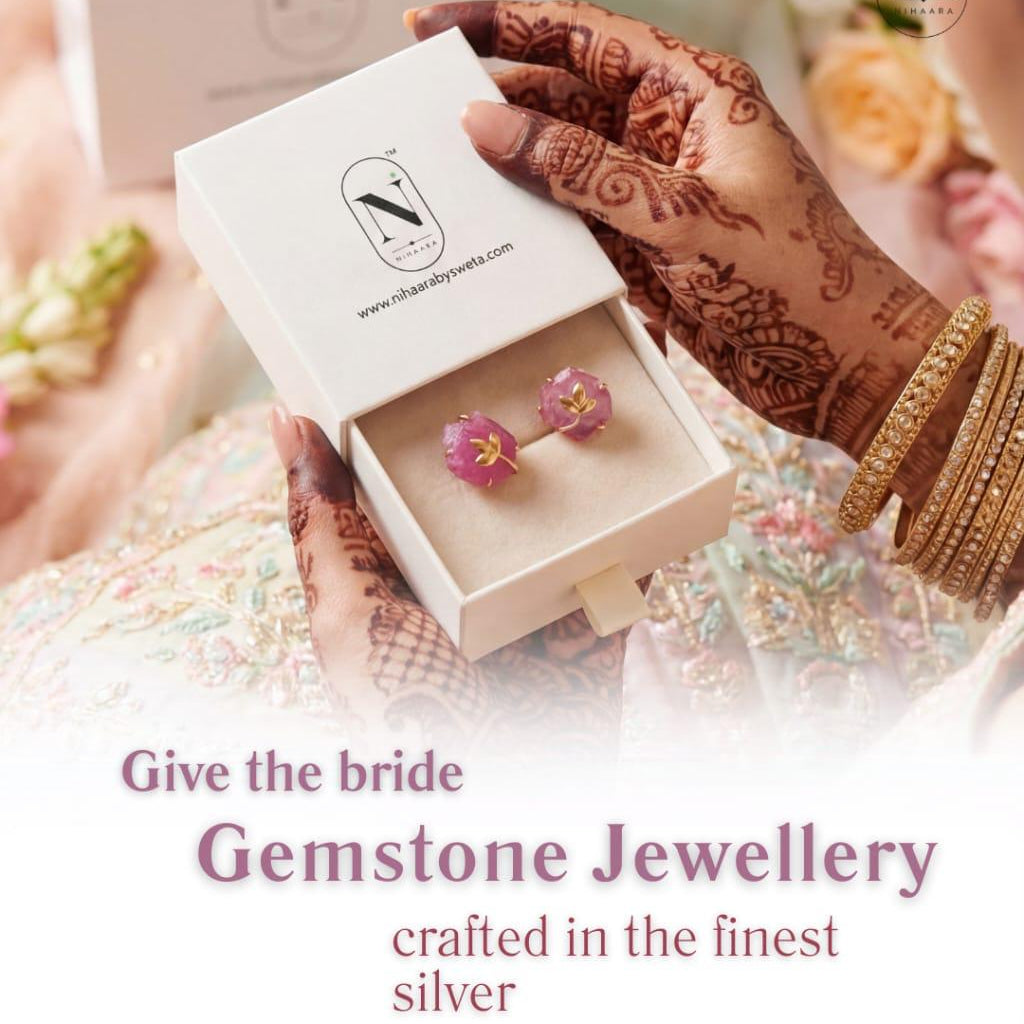 Hand holding a box with gemstone earrings and 'N' brand logo, text 'Give the bride Gemstone Jewellery crafted in the finest silver'.